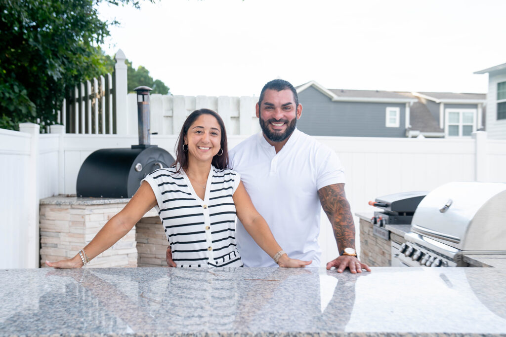 Anna and Rafael Almeida pose together for the camera on a beautiful outdoor patio.